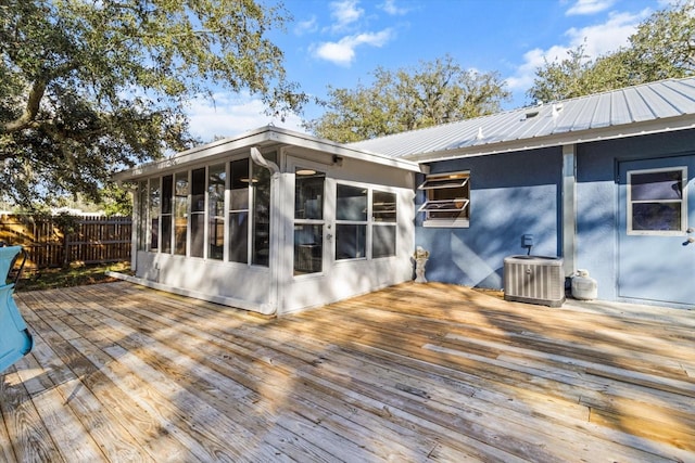 wooden terrace with a sunroom and cooling unit