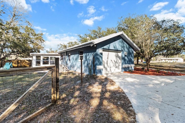 view of home's exterior with a garage and a sunroom