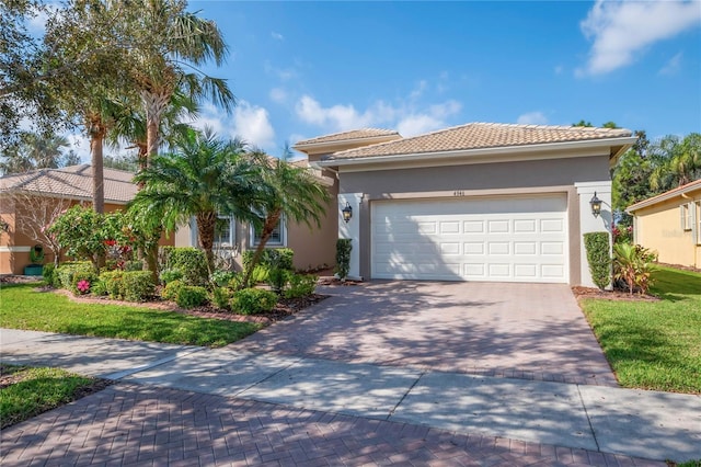 mediterranean / spanish-style house featuring a garage and a front yard