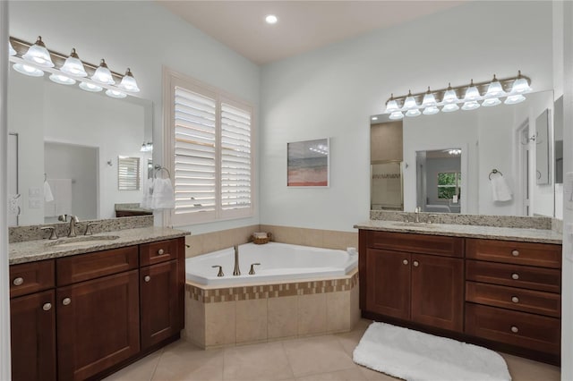 bathroom featuring tile patterned floors, tiled bath, and vanity