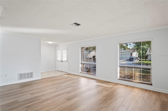 empty room with crown molding, a textured ceiling, and light hardwood / wood-style flooring