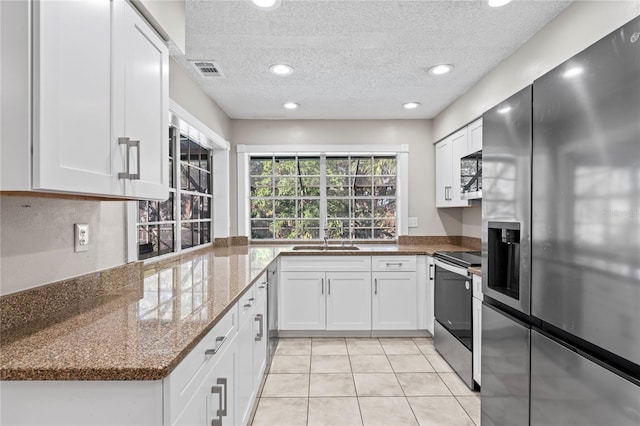 kitchen with white cabinetry, sink, dark stone counters, and appliances with stainless steel finishes