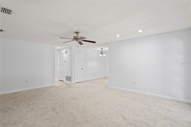 unfurnished room featuring ceiling fan, light colored carpet, and a textured ceiling