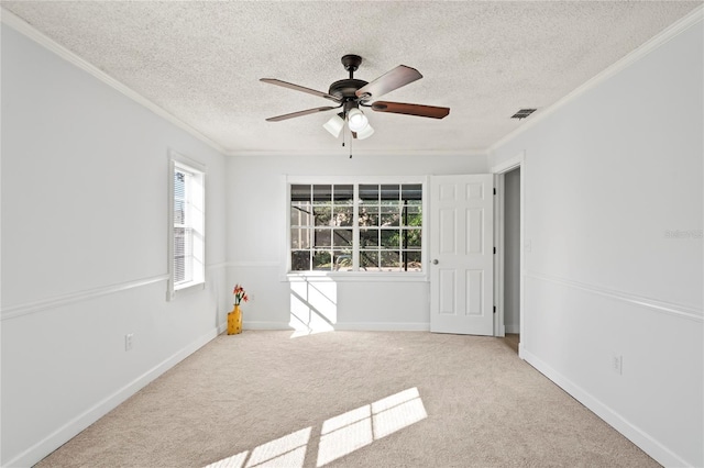 carpeted empty room featuring ornamental molding, ceiling fan, and a textured ceiling