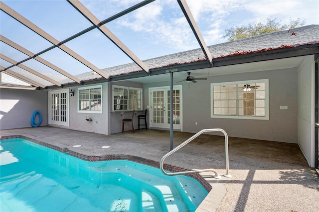 view of swimming pool with a patio area, french doors, ceiling fan, and glass enclosure