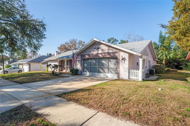 view of front facade featuring central AC, a garage, and a front lawn