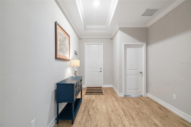 interior space with light wood-type flooring, baseboards, visible vents, and crown molding