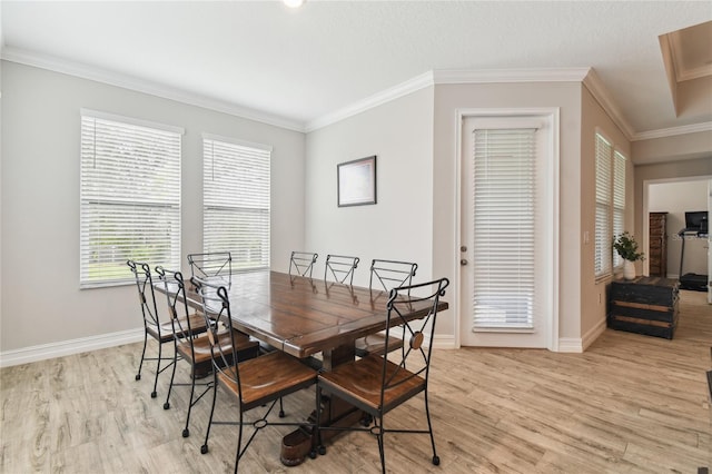 dining area with baseboards, light wood finished floors, and crown molding