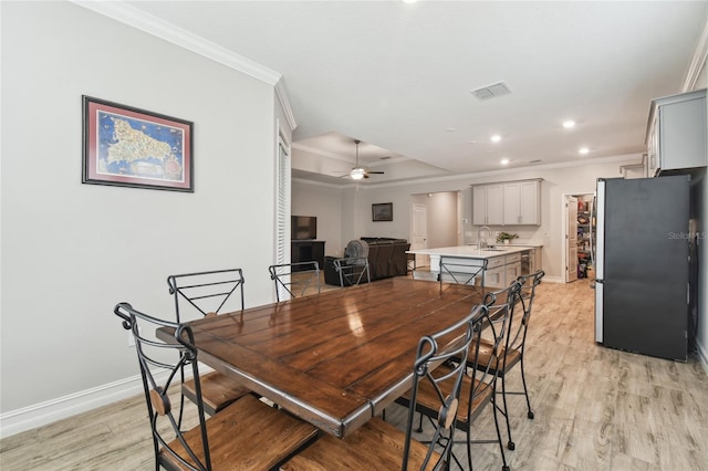 dining space with light wood-type flooring, ceiling fan, visible vents, and ornamental molding