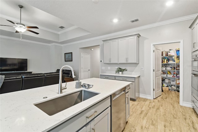 kitchen featuring light wood-style flooring, a sink, visible vents, light stone countertops, and dishwasher