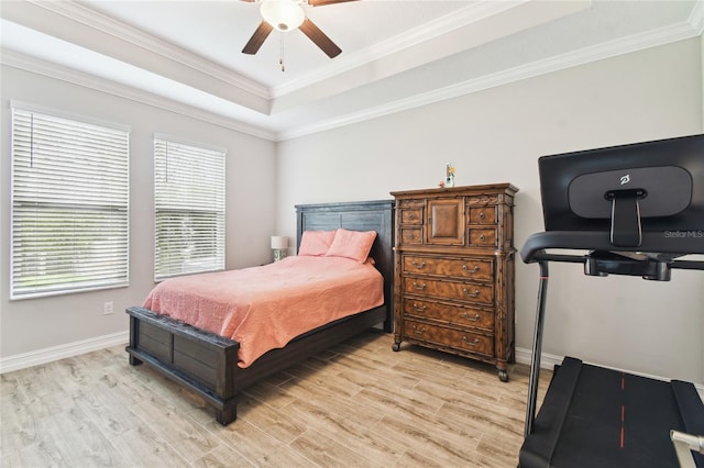 bedroom featuring light wood-style floors, a tray ceiling, and crown molding