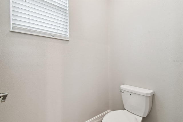 bathroom featuring toilet and baseboards