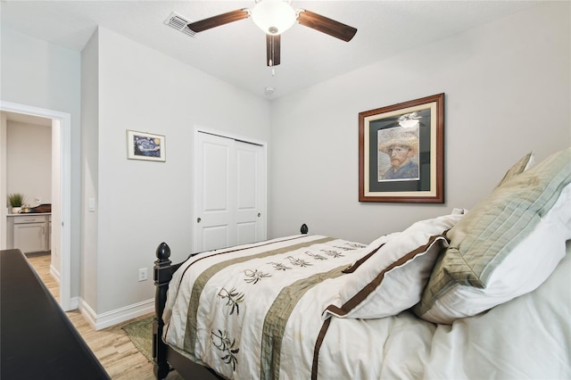 bedroom with visible vents, baseboards, a ceiling fan, light wood-type flooring, and a closet