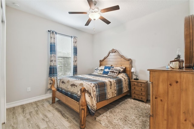 bedroom featuring ceiling fan, baseboards, and wood finished floors