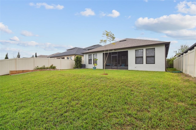 back of property featuring a fenced backyard and a lawn