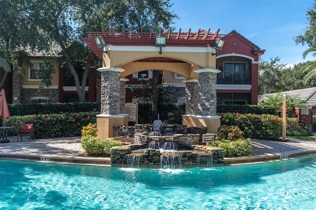 rear view of property featuring pool water feature and a community pool