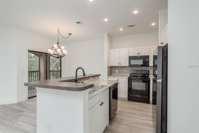 kitchen with sink, black appliances, an island with sink, white cabinets, and decorative light fixtures