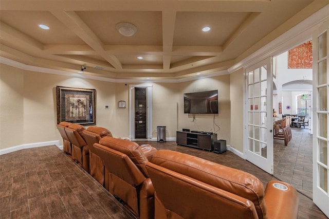 cinema room featuring beamed ceiling, coffered ceiling, crown molding, dark wood-type flooring, and french doors