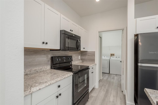 kitchen with white cabinetry, light stone counters, black appliances, washing machine and dryer, and backsplash