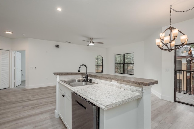 kitchen featuring sink, dishwasher, white cabinetry, an island with sink, and decorative light fixtures