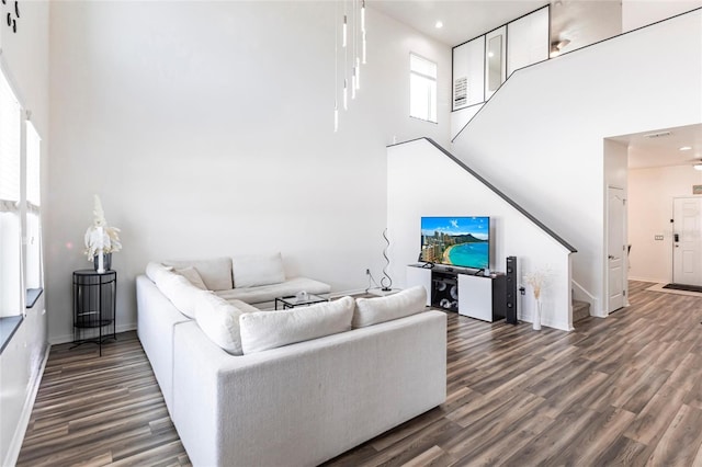 living room featuring a high ceiling and dark wood-type flooring