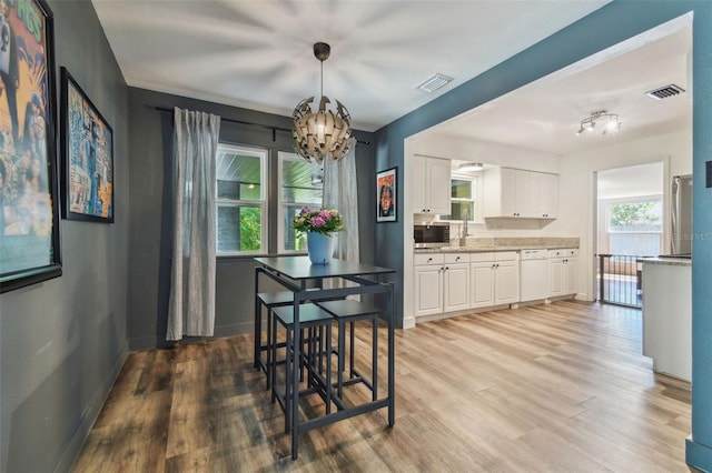 dining room featuring an inviting chandelier and light hardwood / wood-style flooring