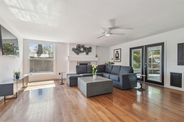 living room with wood-type flooring, french doors, ceiling fan, and plenty of natural light