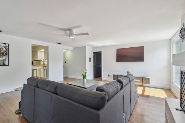 living room featuring wood-type flooring and ceiling fan