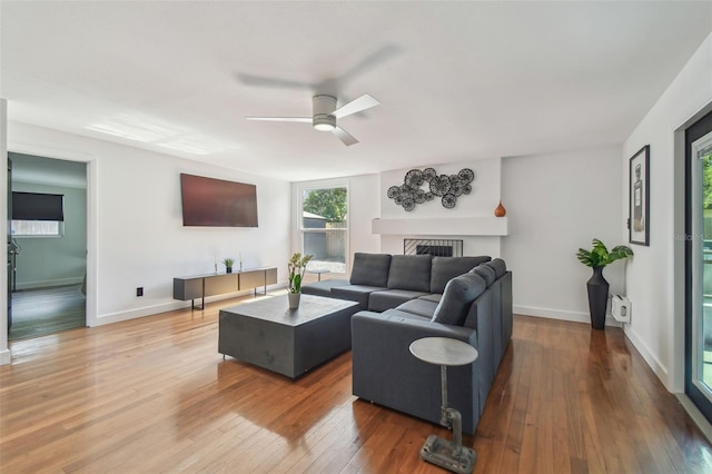 living room featuring wood-type flooring and ceiling fan