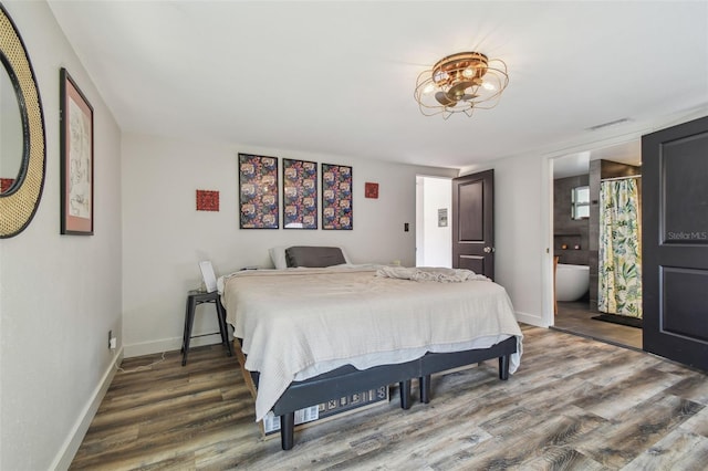 bedroom with hardwood / wood-style flooring and ensuite bathroom