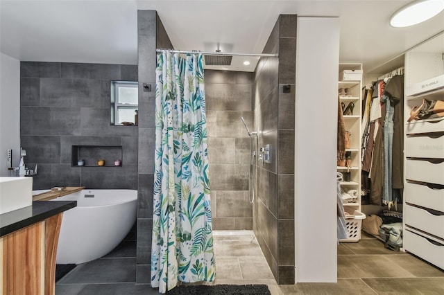 bathroom with tile patterned floors, vanity, curtained shower, and tile walls