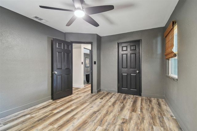 empty room featuring ceiling fan and light hardwood / wood-style floors