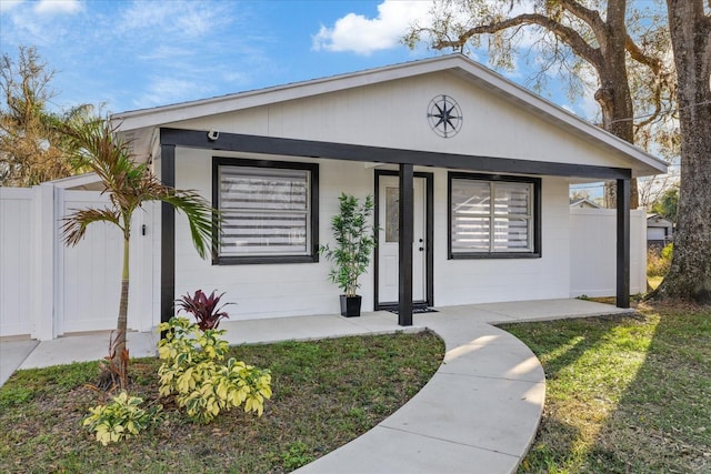 single story home with covered porch and a front lawn