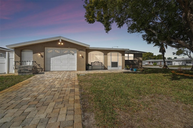 view of front of home with a garage and a lawn