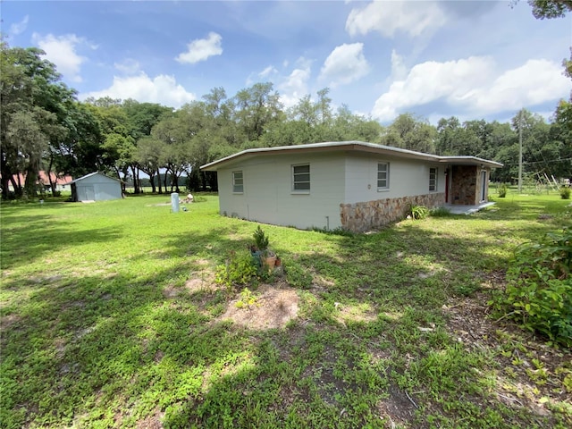 3223 Coats Rd, Zephyrhills, FL 33541 - view of home's exterior featuring stone siding, a lawn, and view of scattered trees