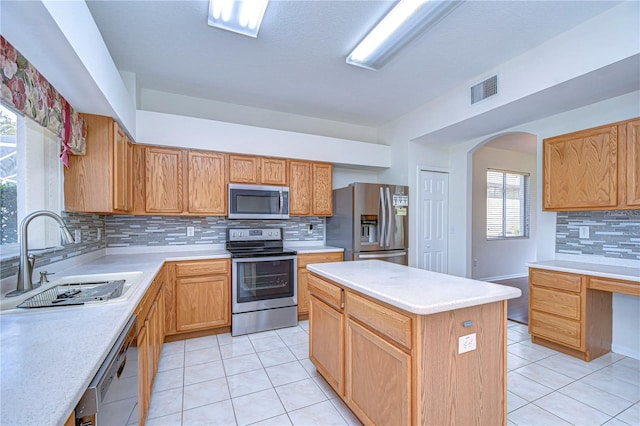 18126 Kara Ct, Tampa, FL 33647 - kitchen with stainless steel appliances, a sink, light tile patterned flooring, backsplash, and light countertops