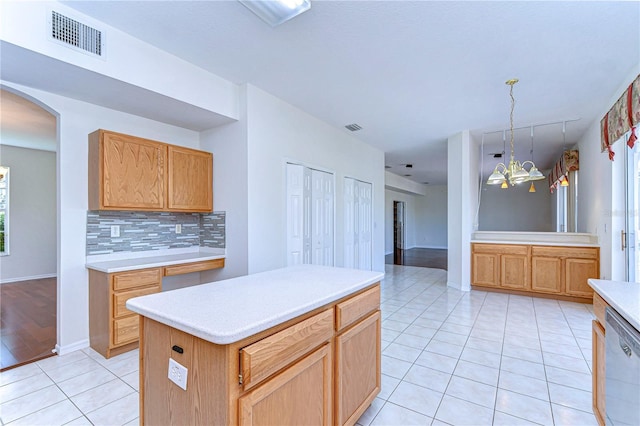 18126 Kara Ct, Tampa, FL 33647 - kitchen with stainless steel dishwasher, a chandelier, light tile patterned floors, decorative backsplash, and arched walkways