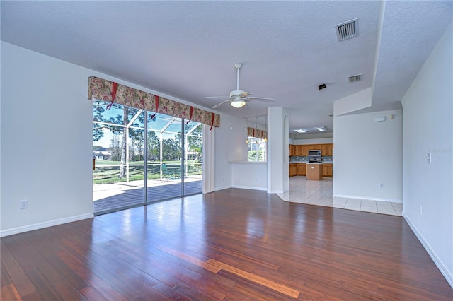 18126 Kara Ct, Tampa, FL 33647 - unfurnished living room with ceiling fan, light wood-style floors, baseboards, and a textured ceiling