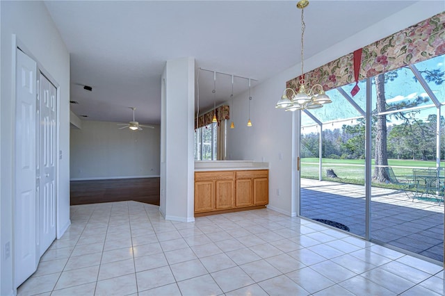 18126 Kara Ct, Tampa, FL 33647 - unfurnished dining area with a ceiling fan, light tile patterned floors, a chandelier, and baseboards