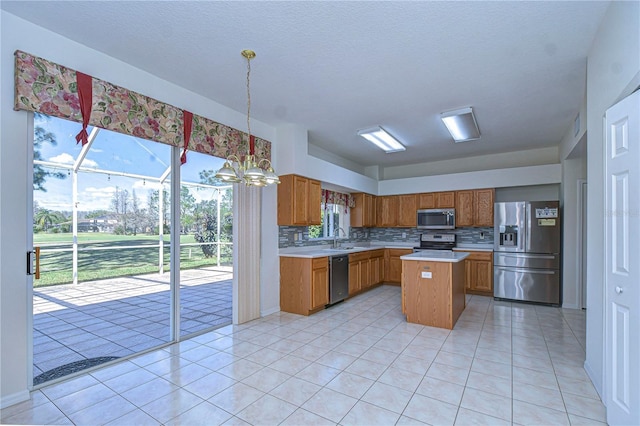 18126 Kara Ct, Tampa, FL 33647 - kitchen with appliances with stainless steel finishes, a sink, light countertops, brown cabinetry, and tasteful backsplash