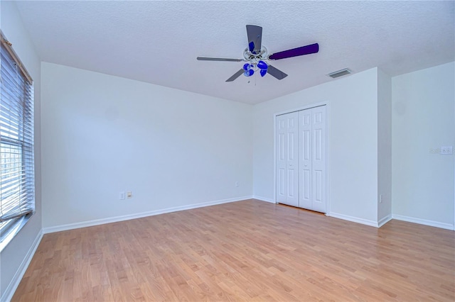 18126 Kara Ct, Tampa, FL 33647 - unfurnished bedroom with light wood-style floors, a closet, baseboards, and a textured ceiling