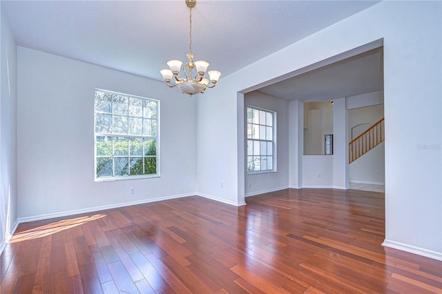 18126 Kara Ct, Tampa, FL 33647 - spare room with a chandelier, plenty of natural light, and hardwood / wood-style floors
