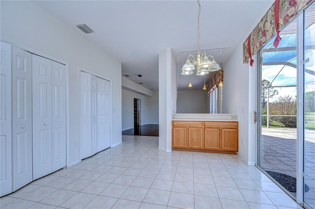 18126 Kara Ct, Tampa, FL 33647 - kitchen with a chandelier, light tile patterned floors, pendant lighting, light countertops, and baseboards