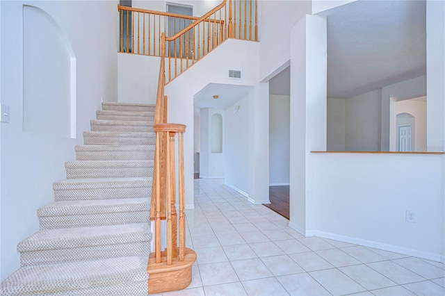18126 Kara Ct, Tampa, FL 33647 - stairway with arched walkways, tile patterned floors, and baseboards