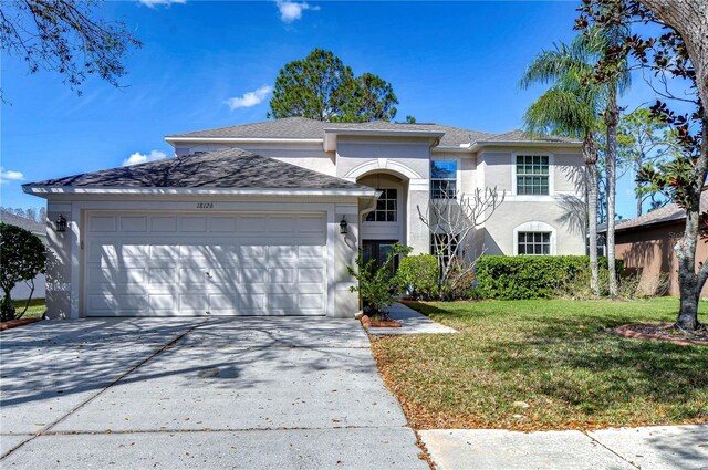 18126 Kara Ct, Tampa, FL 33647 - view of front facade with driveway, a garage, a front yard, and stucco siding