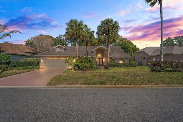 view of front of home with a garage and a yard