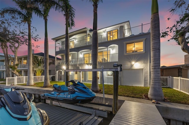 back of property at dusk with fence and stucco siding