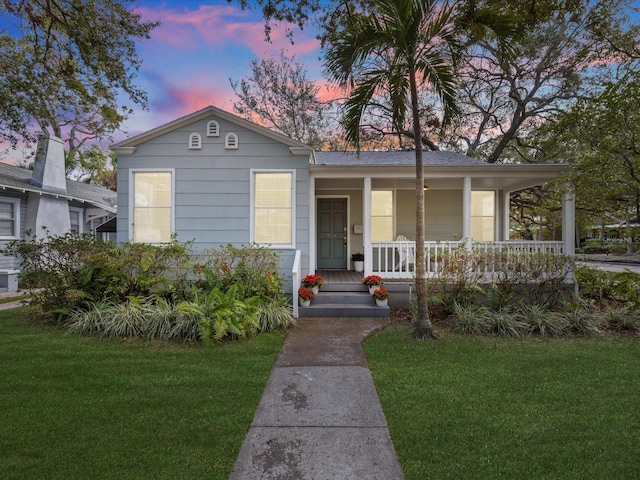 view of front of property with a yard and covered porch