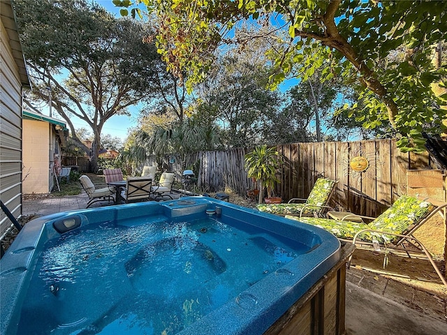 view of swimming pool with a hot tub