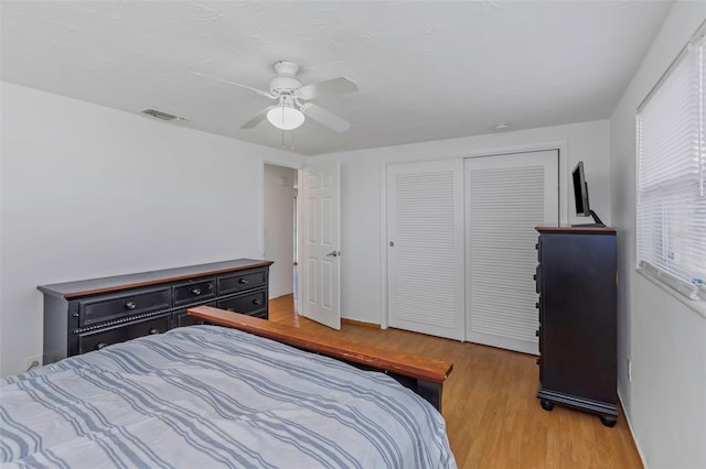 bedroom with light hardwood / wood-style flooring, a closet, and ceiling fan